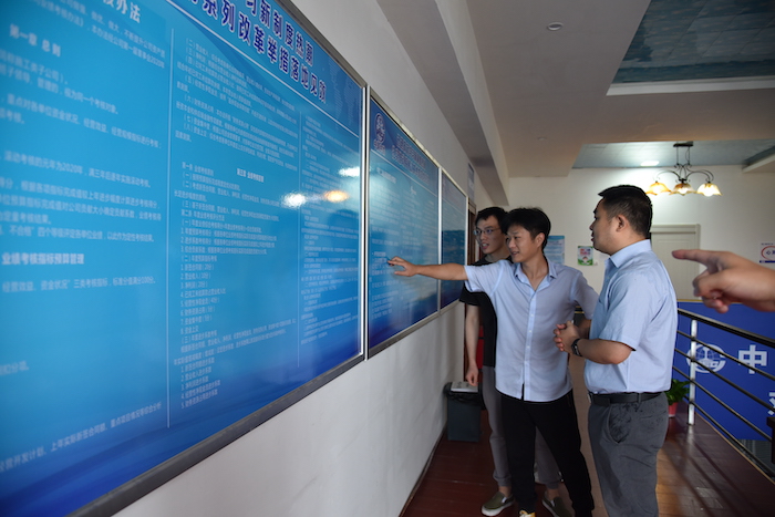 图2：员工在制度展板前交流学习.JPG